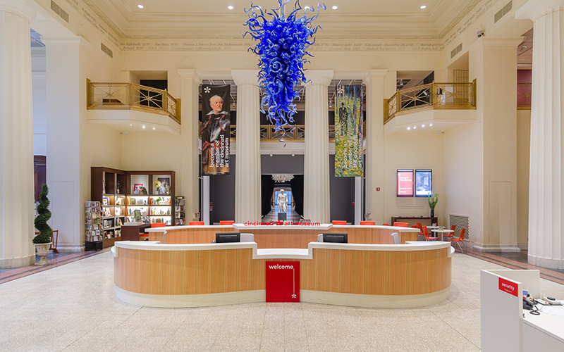 The main lobby of the museum, featuring the front desk and a large blue glass chandelier