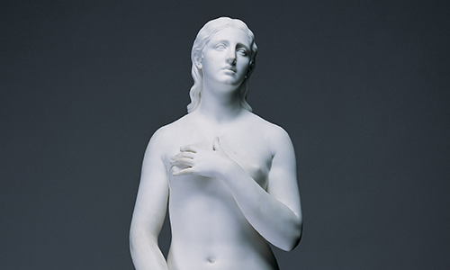 A white marble sculpture of a nude woman holding an arm across her chest