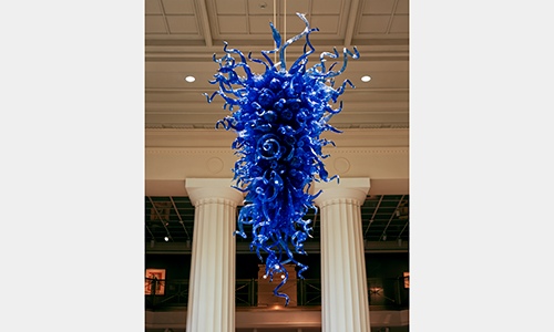 A large, shiny, blue sculpture made of many tendrils.