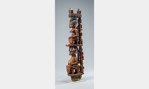 An ornately-carved wooden column with stacked figures.