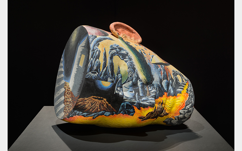 A head-shaped vessel with a colorful landscape painting on the surface