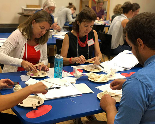 A group of adults eat at a workshop