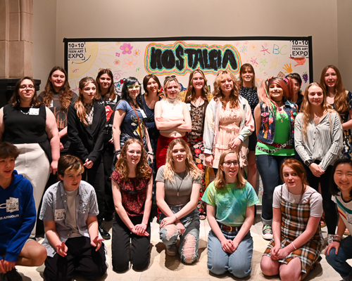 A group of young people pose in front of a  10 x 10 Teen Art Expo banner
