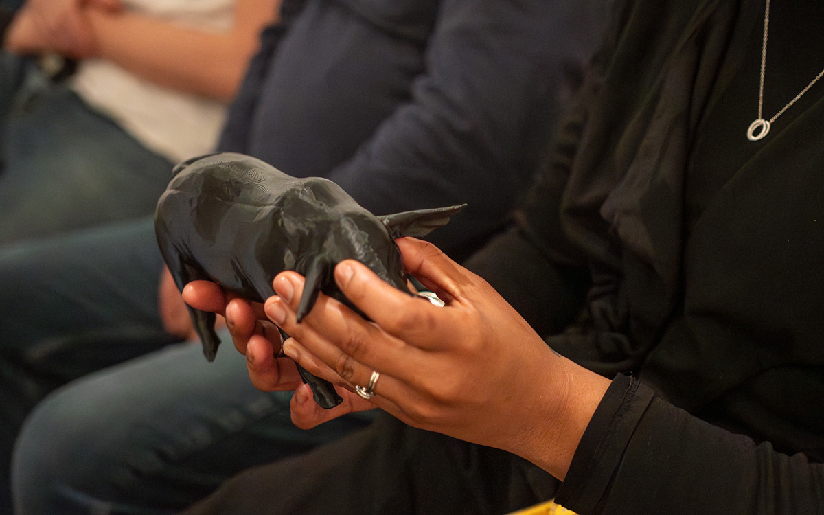 A Black person touches a 3D print of a sculpture