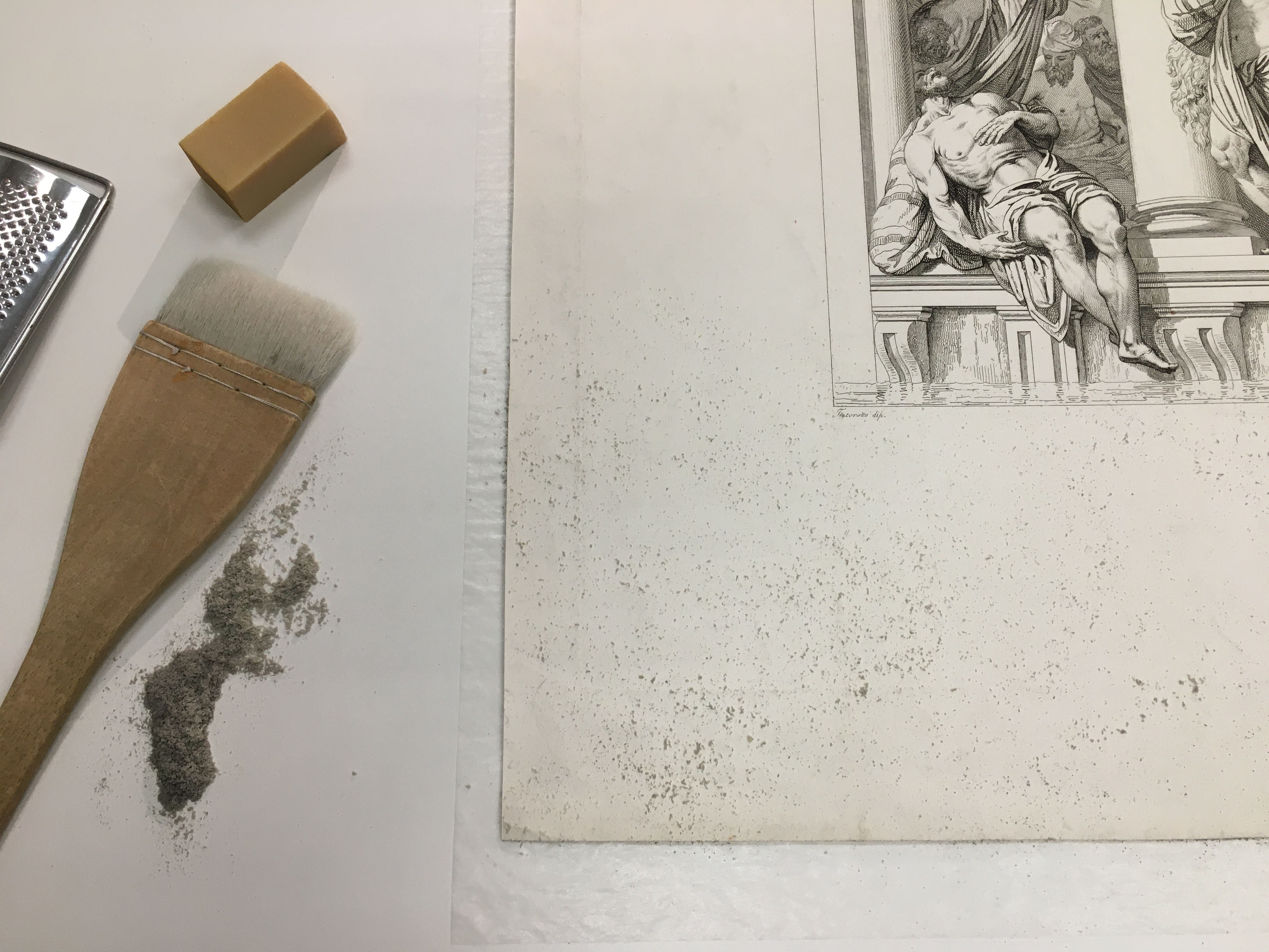 Brush and dark eraser crumbs on corner of print