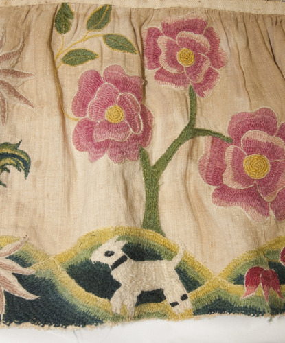 embroidery of a small lamb and large pink flowers