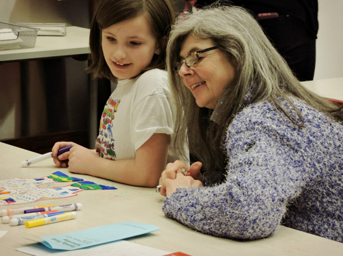 a young girl and woman inspect hieroglyphs in the Rosenthal Education Center