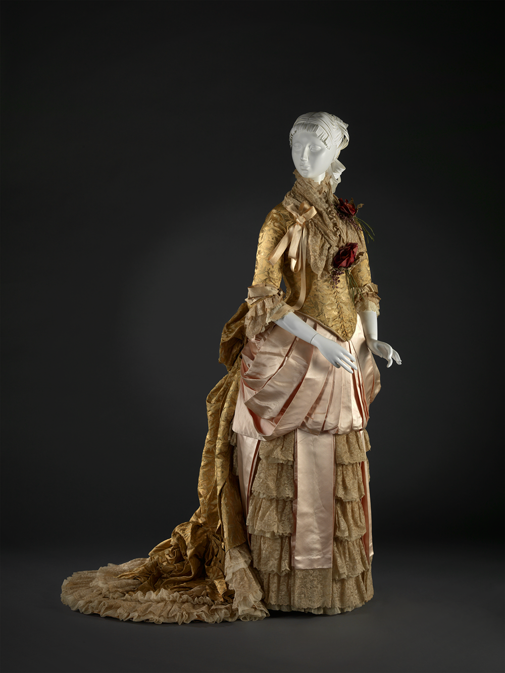 golden dress layered in ruffles with a short train and forearm length sleeves