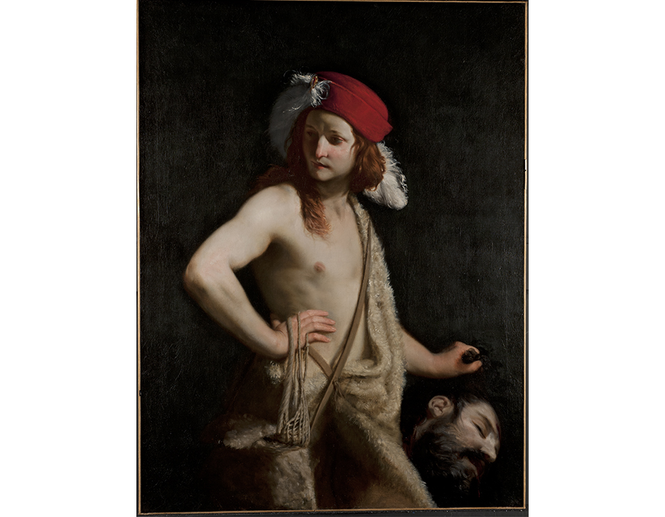 Guido Cagnacci's David Holding Goliath's Head, a painting of a shirtless David wearing a red feathered cap. His right hand is placed on his hip with with sling hung over the wrist. He hold the head of Goliath in his left hand 