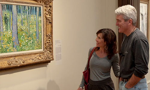 Visitors inspect a painting