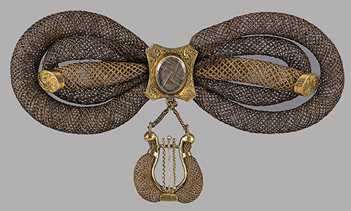 golden coils in the shape of the infinity symbol with a harp dangling below