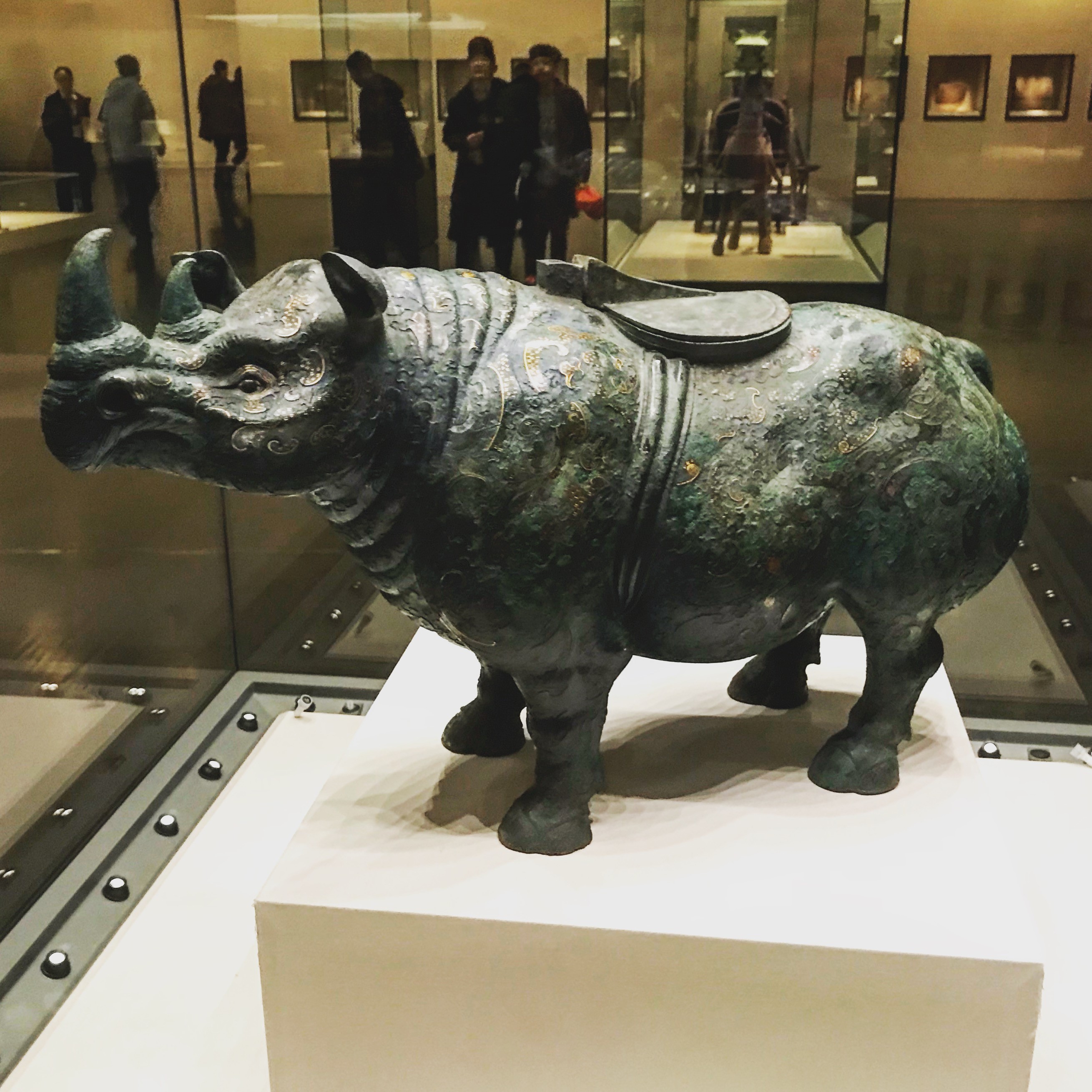 bronze statue of a rhinoceros with a saddle