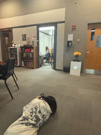 The student lies on the floor to take their picture