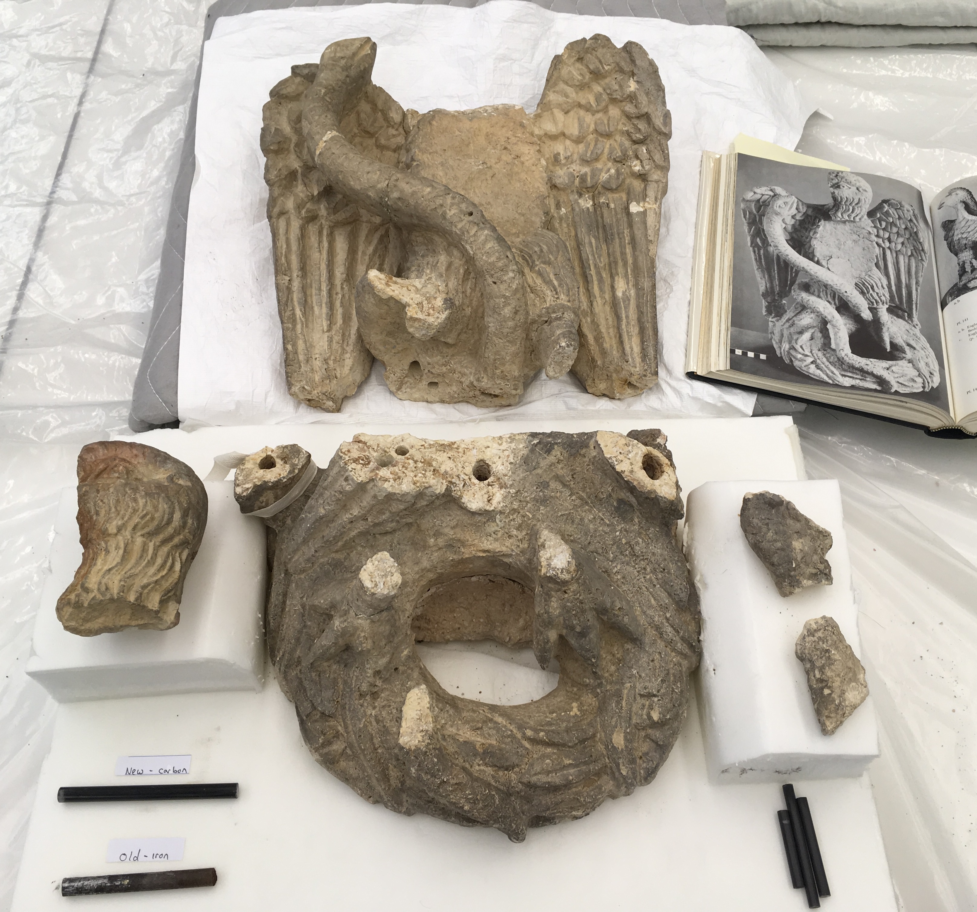 pieces from a stone statue of an eagle and serpent