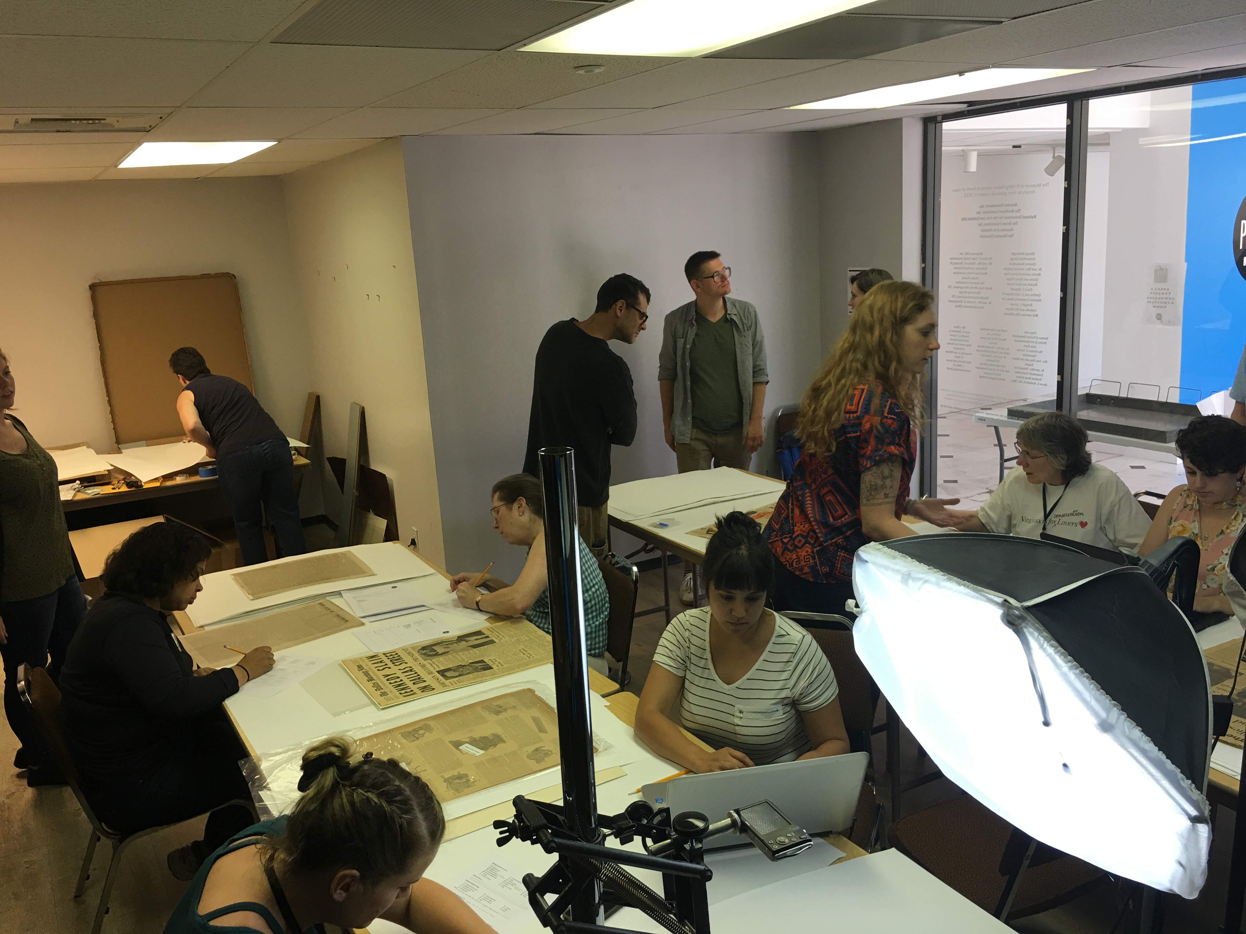 a small group works to document a collection of old newspapers