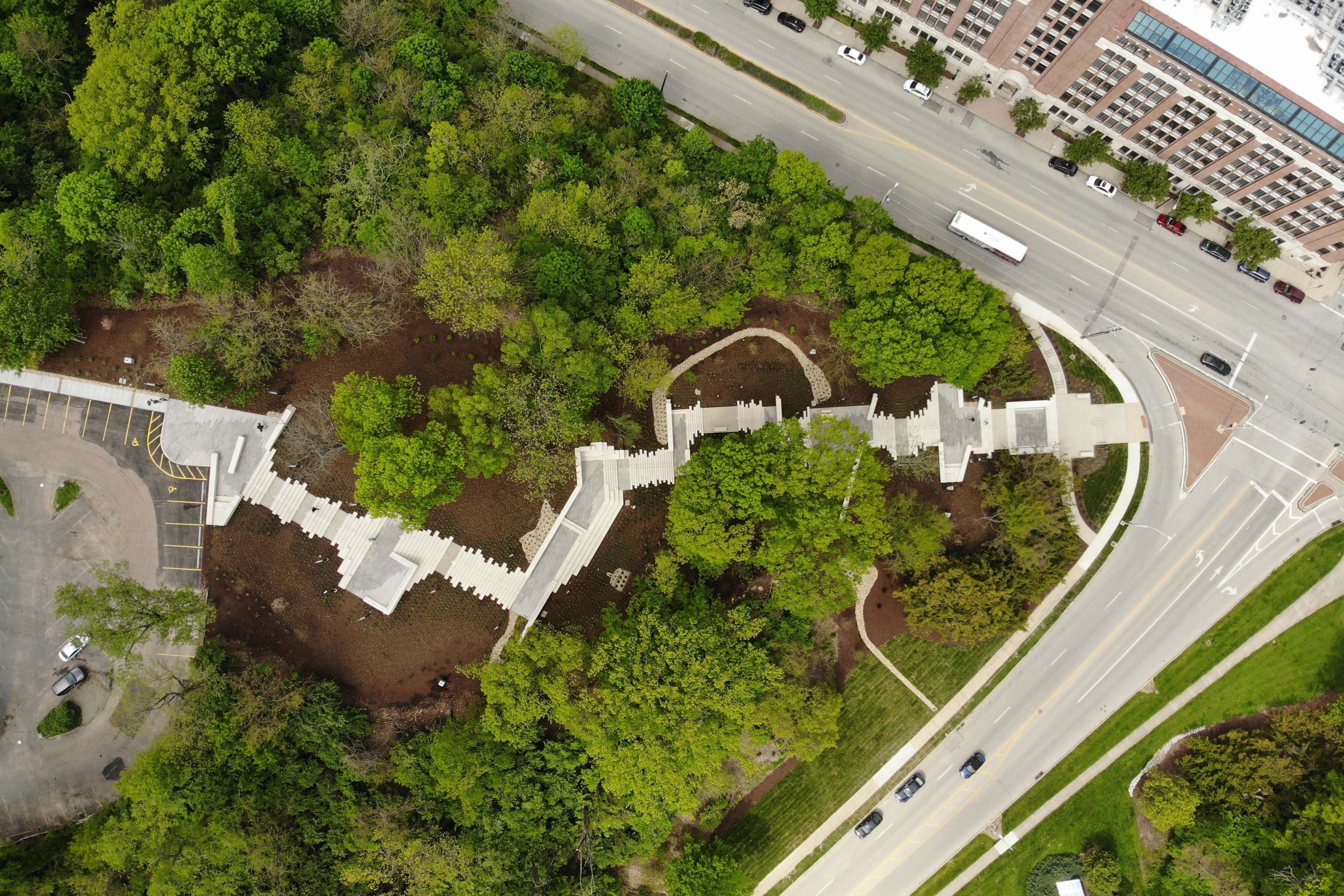 Aerial view of a series of steps and landings climbing up a wooded hillside.
