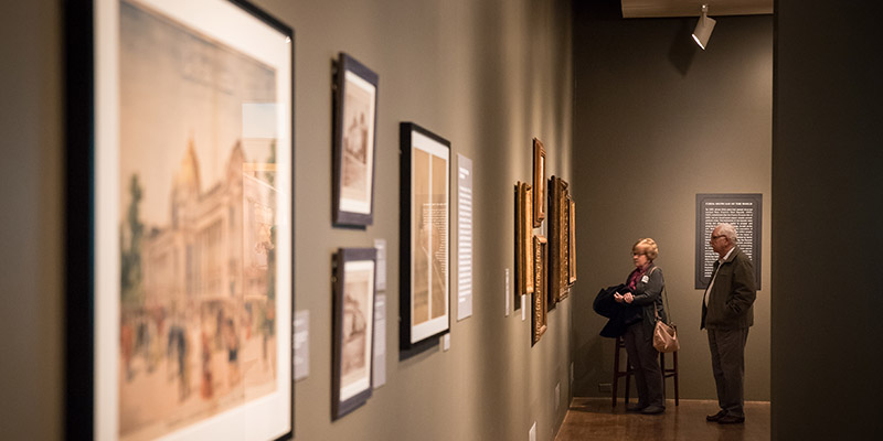 Two visitors admire the various artwork in a hall of the exhibition 