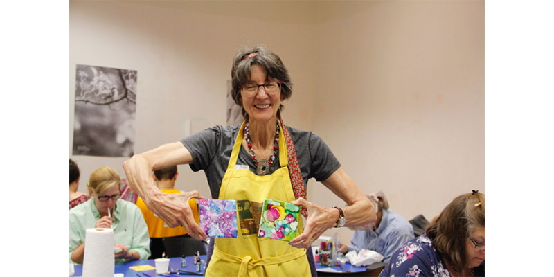 Teacher posing with painted coasters