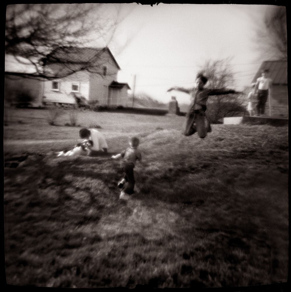 blurry black and white photo of children playing in a field
