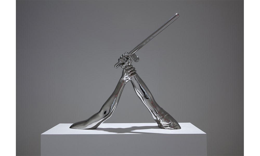 Hank Willis Thomas' Strike, a steel sculpture of two outstretched arms. The arm on the left holds a baton in a striking motion. The arm on the left grips the other at the wrist