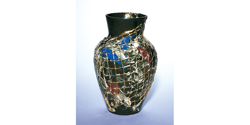 Maria Longworth Nichols Storer's Vase, a large wide neck vase with a metallic net pattern covering red and blue fish swimming around black and white currents