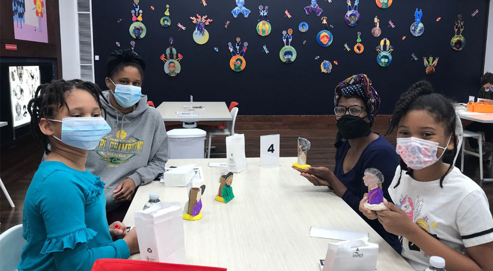 Visitors wear masks working on arts and crafts