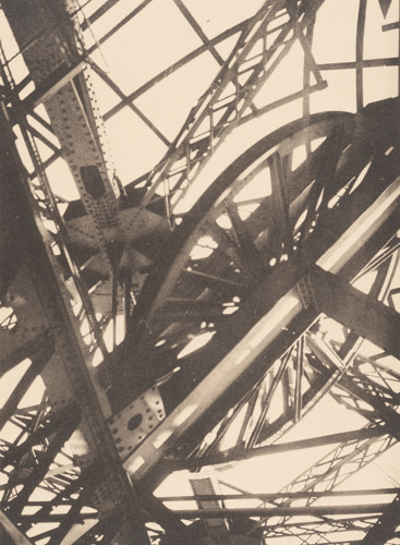 sepia photo of a large metal structure with a wheel and steel cables