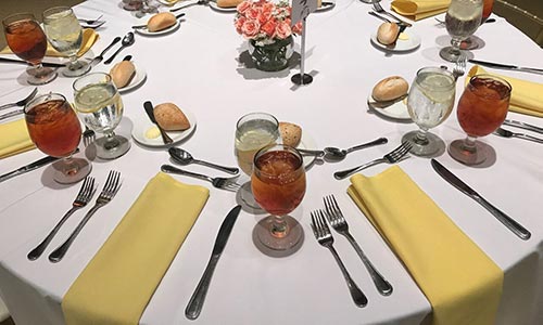 An elaborate spread featuring two drinks and bread and butter at a round table