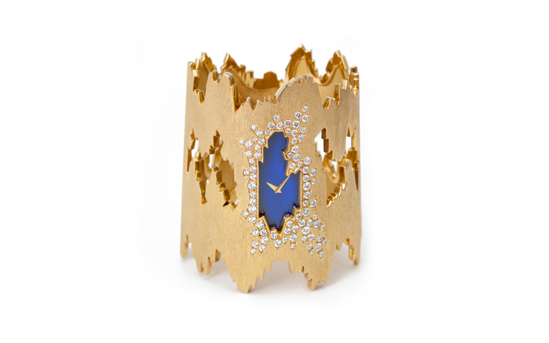 Chopard's Alexandra Watch, a fragmented, gold, cuff bracelet, with small diamonds surrounding an hour and minute hand on a blue background