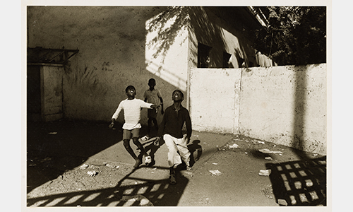 Three Black kids look to the sky