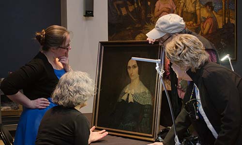 Visitors inspect a painting