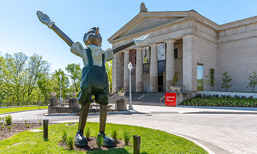 Pinocchio welcomes visitors to the Cincinnati Art Museum main entrance on a beautiful, sunny day.