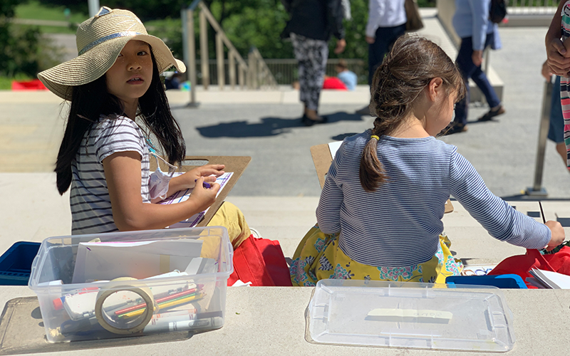 A young person looks over their shoulder while making art on the Art Climb