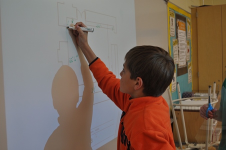 student tracing the outline of a diagram