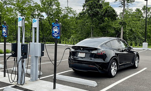 A Tesla is charging in the parking lot at the museum