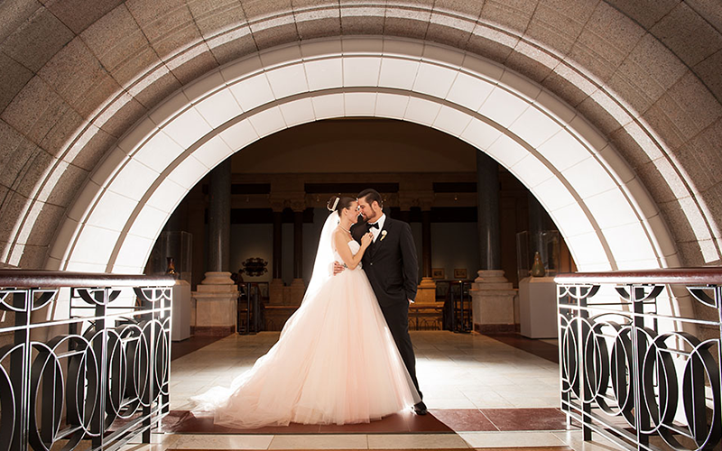 A couple stands in an arch at the museum