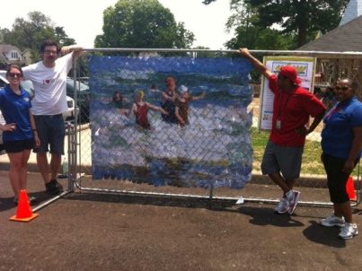 Community Canvas mural hung on a community pool fence