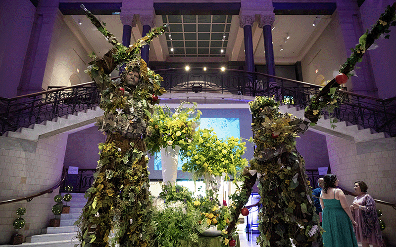 Two performers on stilts covered with greenery