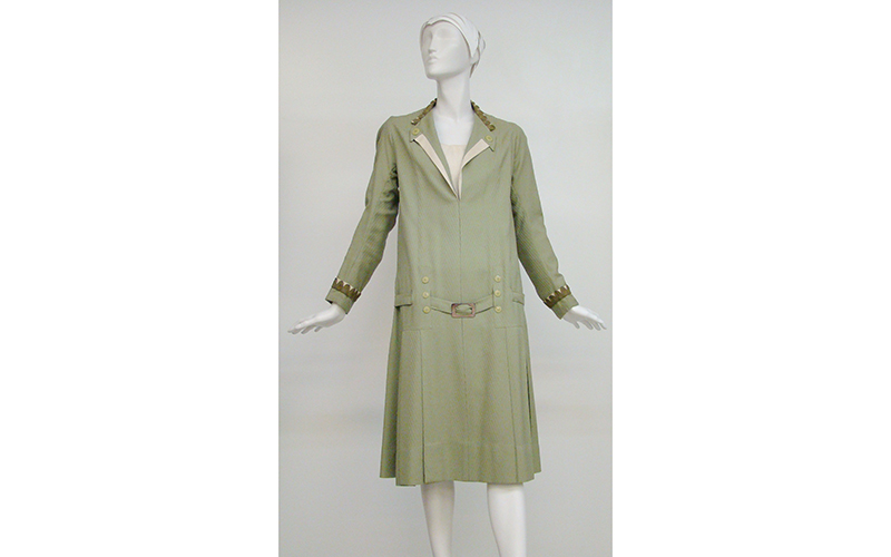 Sage green knee-length long-sleeved dropped-waist dress with metallic trim. 