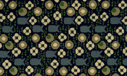 Rectangular piece of carpet with a design of flowers, circles, and fish-shaped forms in blue, green, and beige on a black ground. 