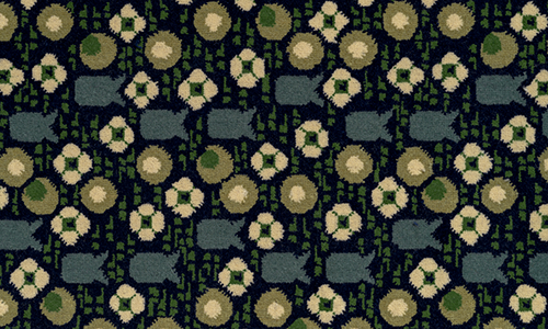 Rectangular piece of carpet with a design of flowers, circles, and fish-shaped forms in blue, green, and beige on a black ground.