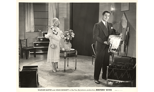 A film still from 1931 depicting a man and woman standing in a circular interior