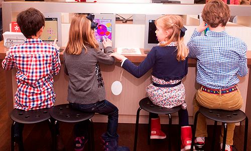 Children sit at stools in the REC