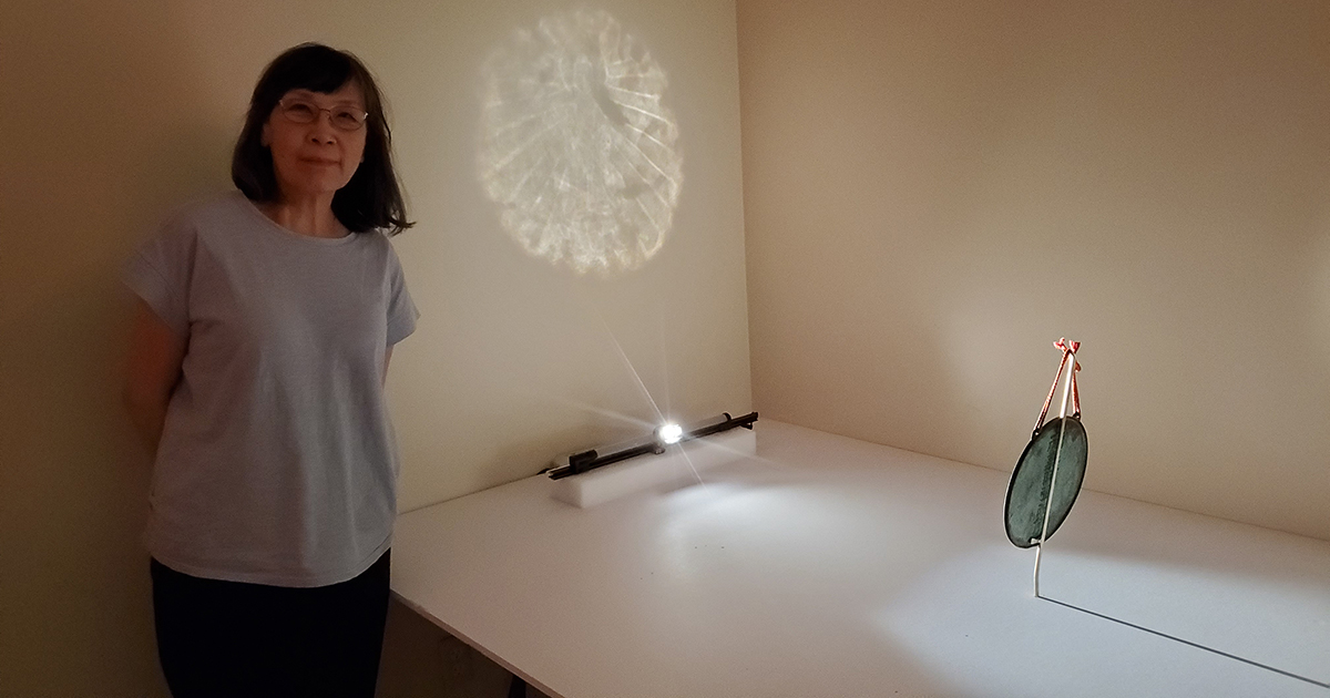 Hou-mei Sung, Ph.D. 宋后楣, Cincinnati Art Museum’s Curator of East Asian Art is shown next to the Buddhist Bronze Mirror