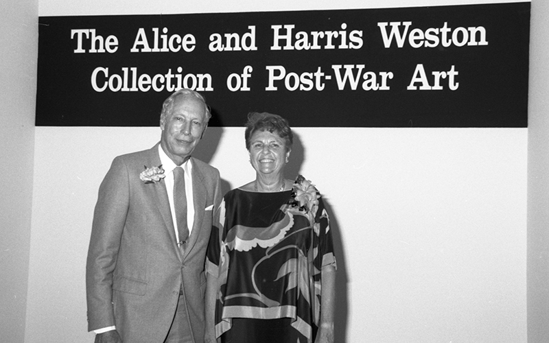 Alice and Harris Weston pose in front of a sign for their collection
