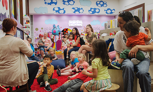 CAM staff read to a room full of dozens of parents and children