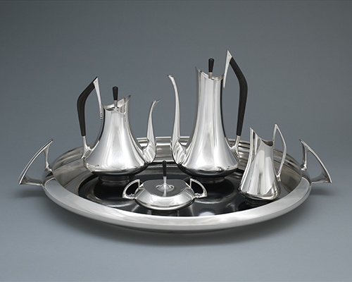 A modern, polished silver tea set including tray