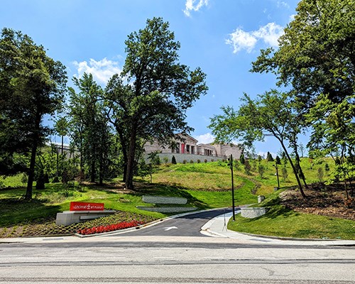 The front drive of the museum, with green rolling hills and tall green trees