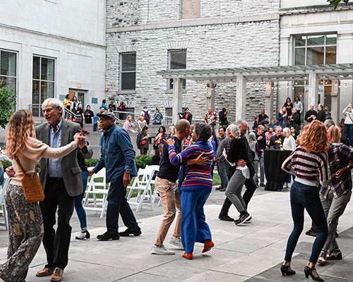 Visitors dance in the courtyard