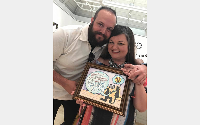 James and Alicia smile with James' artwork